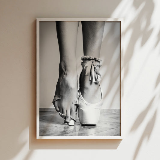 a black and white photo of a woman's feet in ballet shoes