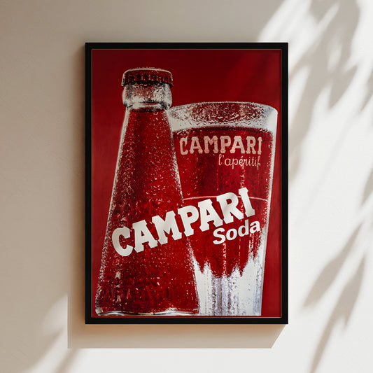 A framed advertisement for Campari soda, featuring a close-up of a red Campari bottle and a glass of Campari soda.