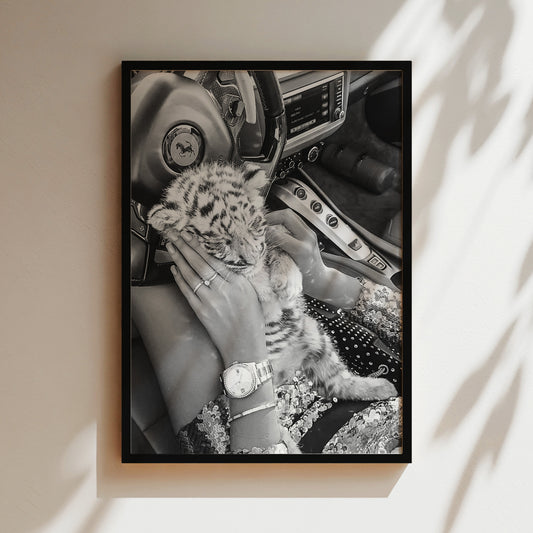 a black and white photo of a woman holding a baby tiger