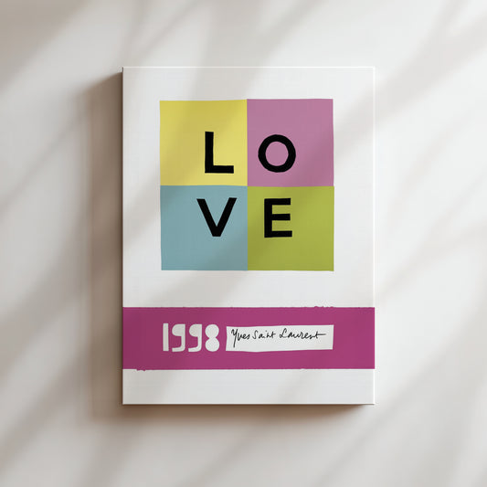 The image is a poster with the word "LOVE" prominently displayed in the center, surrounded by four different colored squares. Below the poster, there is a pink band with the text "1998 You Saint Louis" written on it.