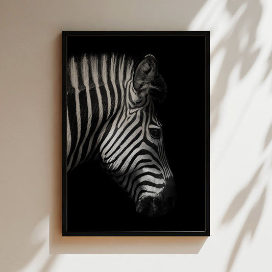 A black and white photograph of a zebra's head, with its distinctive striped pattern prominently featured against a dark background.