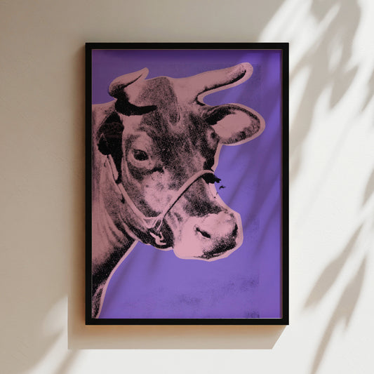 a picture of a cow is hanging on a wall