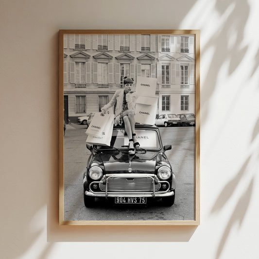 a black and white photo of a woman standing on top of a car