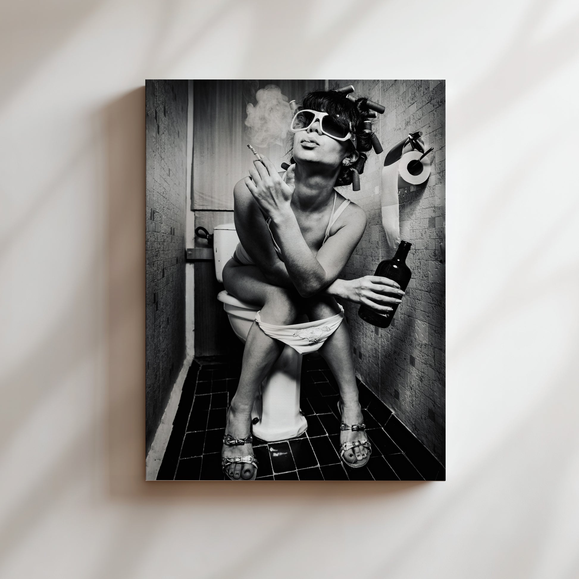 A black and white image of a woman sitting on a toilet in a bathroom, smoking a cigarette and holding a bottle of alcohol.