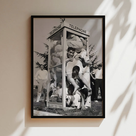 a black and white photo of a group of men in front of a telephone booth