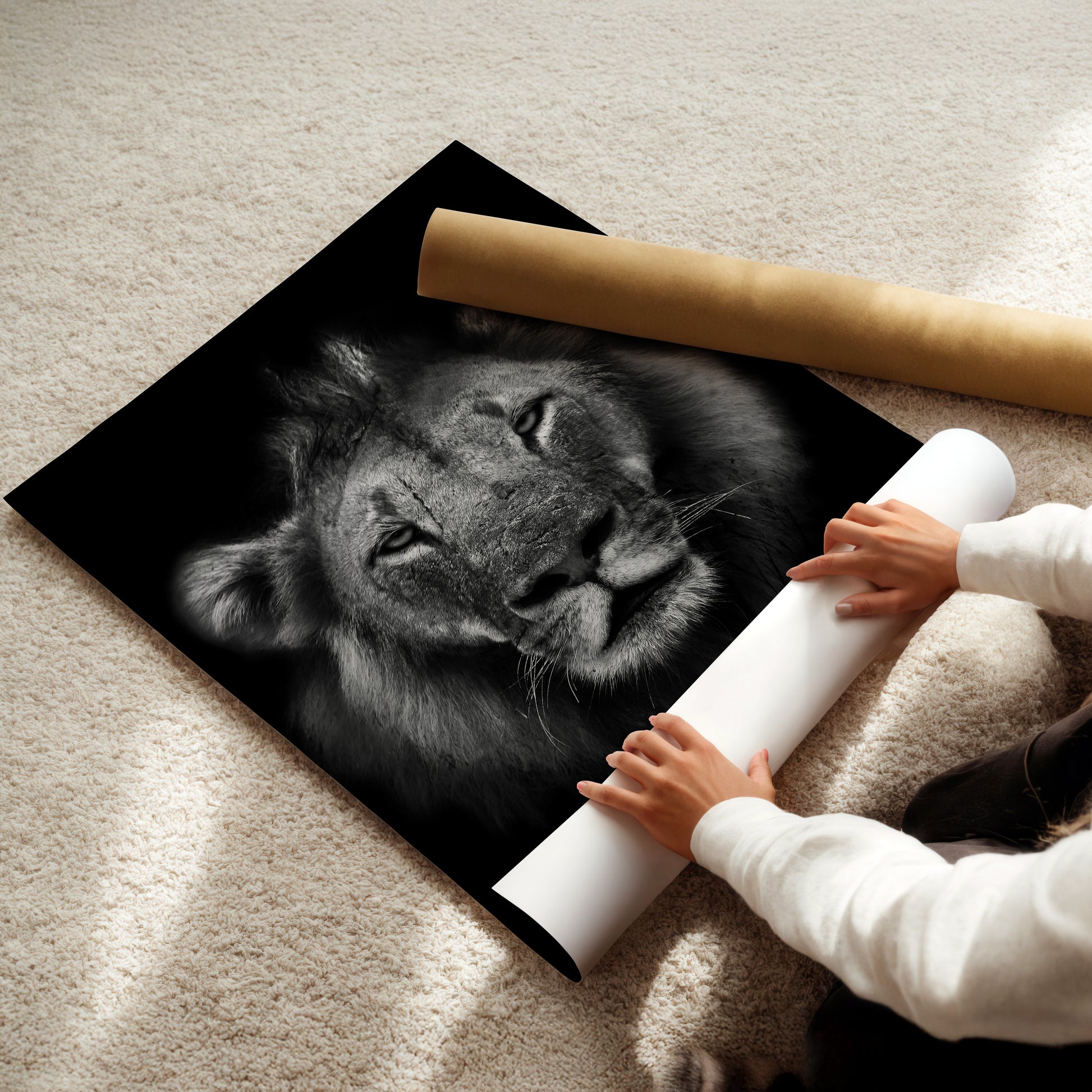 A person is holding a roll of paper in front of a large black and white photograph of a lion's face.