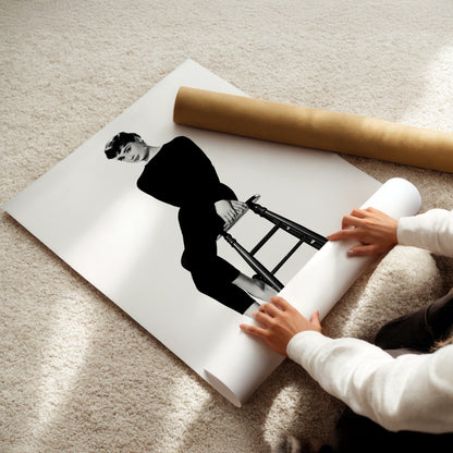 A person is holding a roll of paper and placing it on top of a printed image of a woman sitting on a stool.