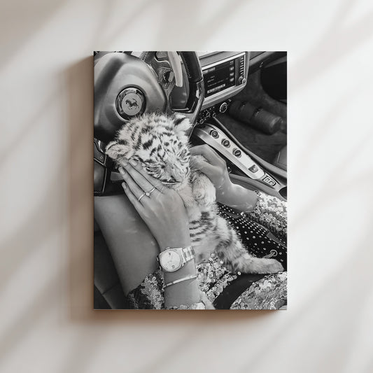 a black and white photo of a woman holding a baby tiger