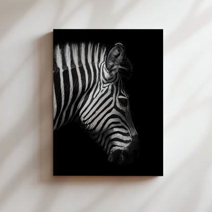 A striking black and white portrait of a zebra's head, with its distinctive black and white stripes and prominent features such as the eyes and nose clearly visible.