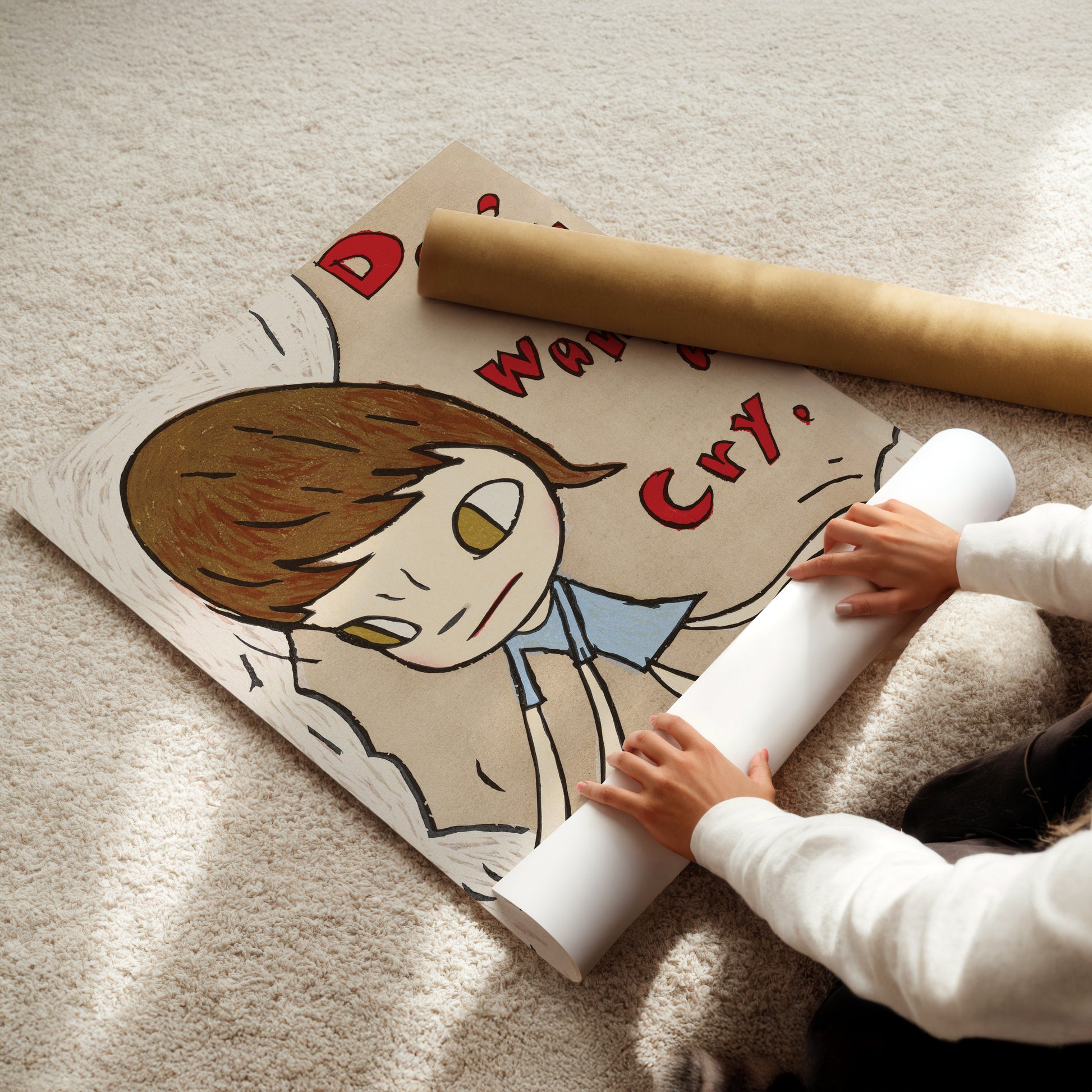 a little girl sitting on the floor with a roll of paper in front of her