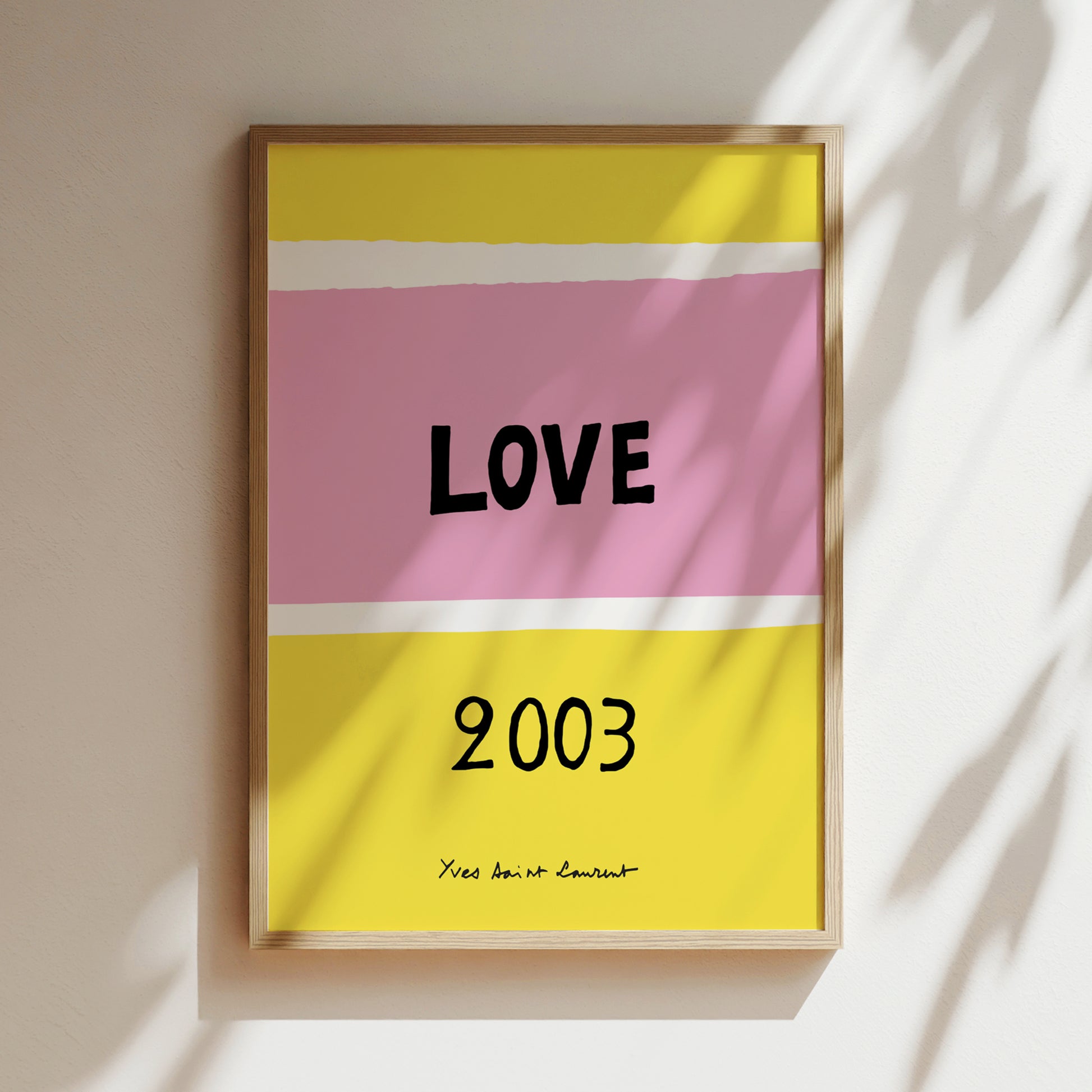 The image is a framed poster with a pink and yellow background, displaying the word "LOVE" in bold black letters. Below the word, the year "2003" is written in black.
