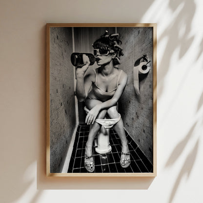 A black and white photograph of a woman sitting on a toilet in a bathroom, wearing sunglasses and holding a bottle.