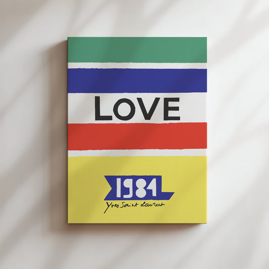 The image is a colorful poster with the word "LOVE" prominently displayed in the center. Below the word "LOVE", there is a small text that reads "1984 Yves Saint-Laurent".