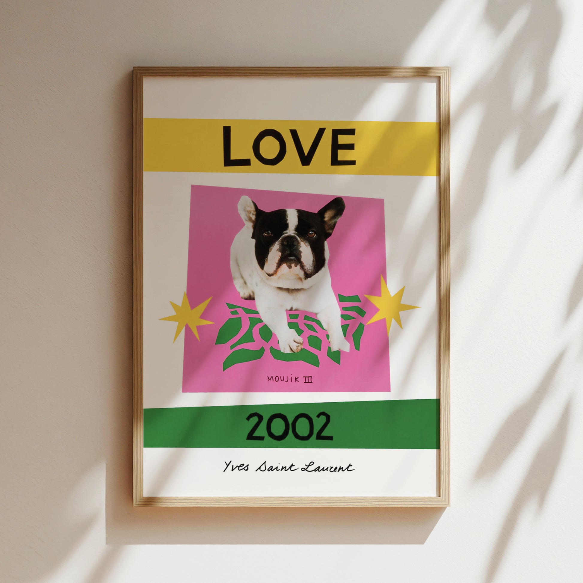 A framed poster with a black and white dog on a pink background, surrounded by yellow and green elements. The text "LOVE" is prominently displayed above the dog, and the year "2002" is shown below it.