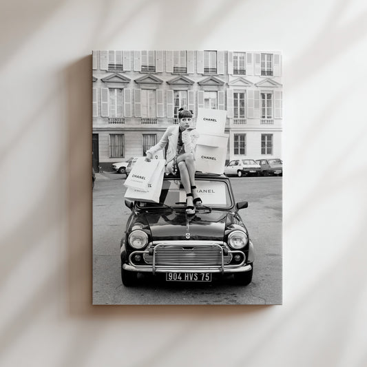a black and white photo of a man sitting on top of a car
